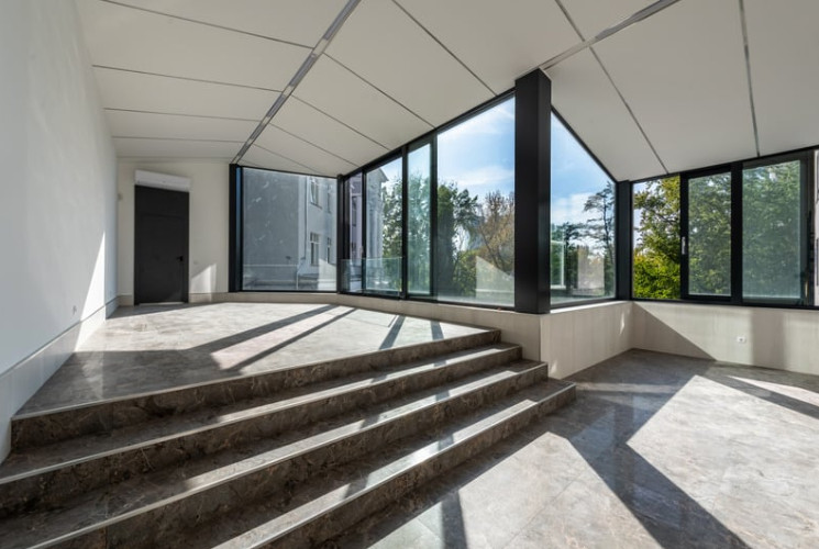 A stylish, sunlit interior displays a variety of the best window styles, perfectly suited for modern living. For example, floor-to-ceiling picture windows frame scenic outdoor views, while casement windows open wide for fresh air.